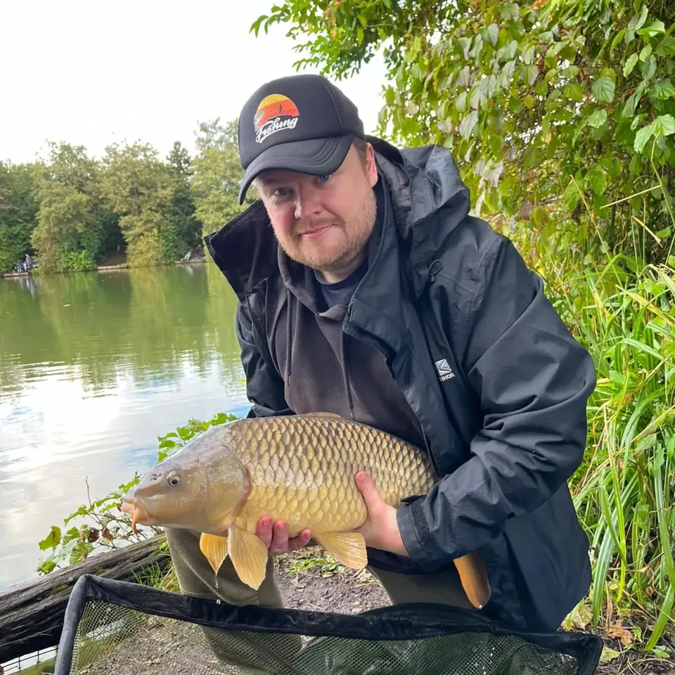 Angler holding a common carp caught at Wood Lane Fishery in Iver, Buckinghamshire